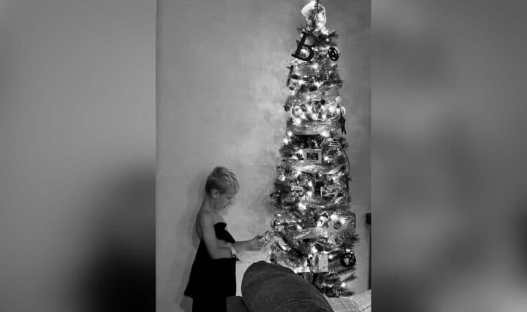 Tree with child standing next to it, black and white image