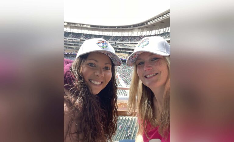 Two women at a sporting stadium, color photo