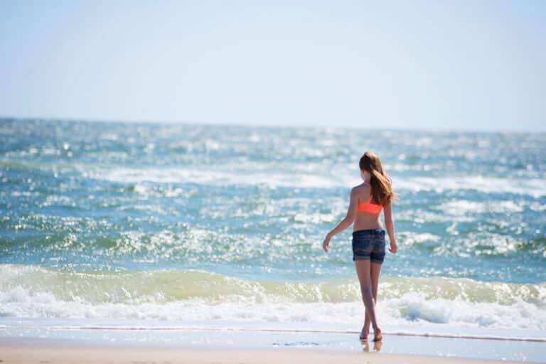 Tween girl walking into ocean waves