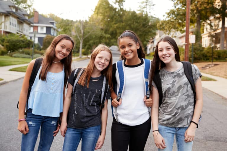 Teen girls walking to school with backpacks