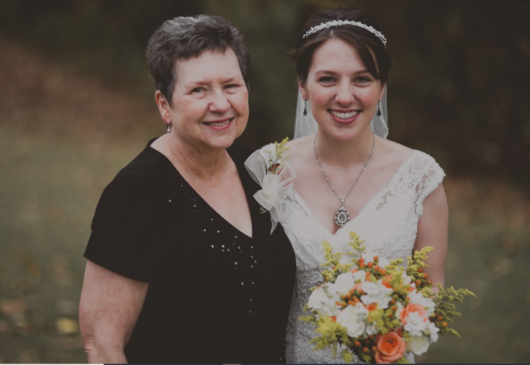 bride and mother, posing and smiling together, color photo