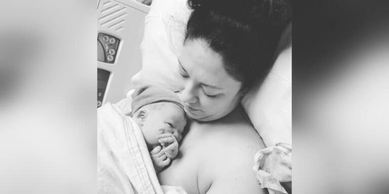 Mother with newborn baby on chest, black and white image