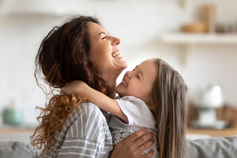 Mother hugging daughter smiling
