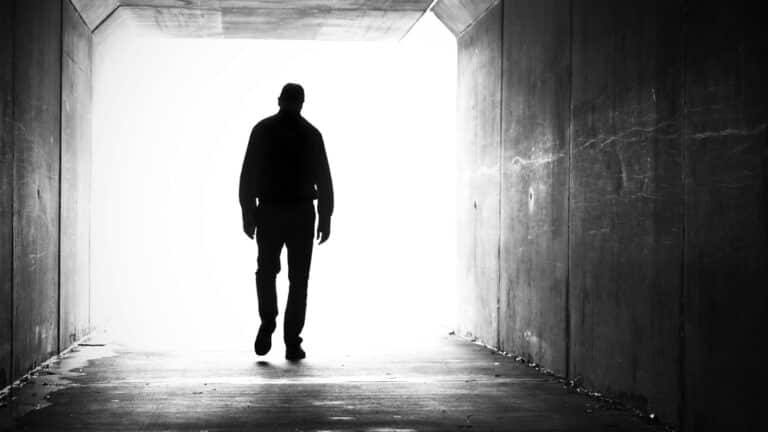 Man walking in tunnel, black and white image