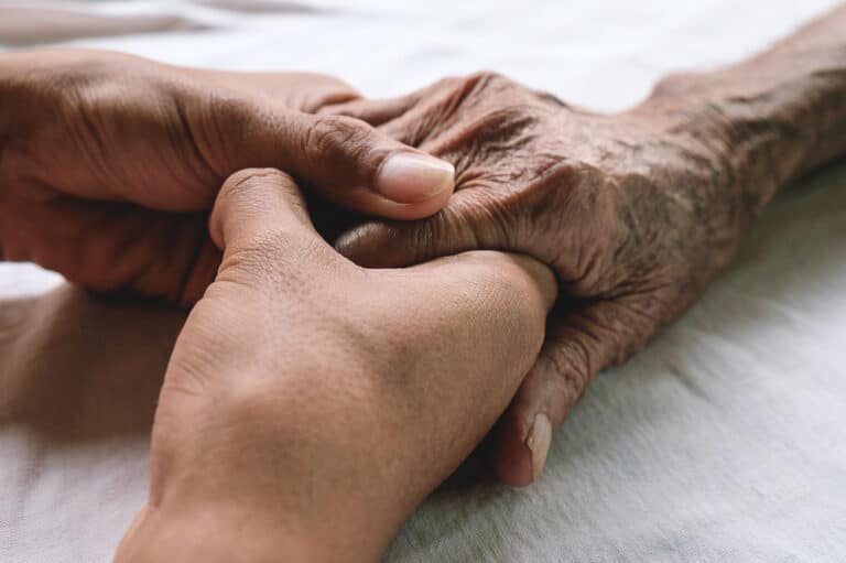 Hands holding elderly hand