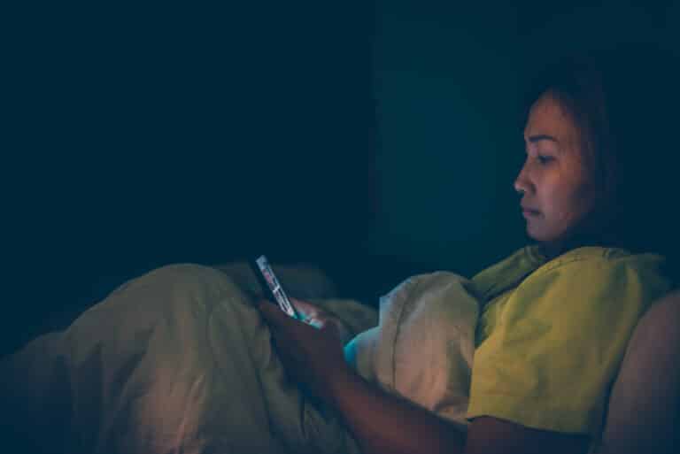Woman looking at smartphone in the middle of the night
