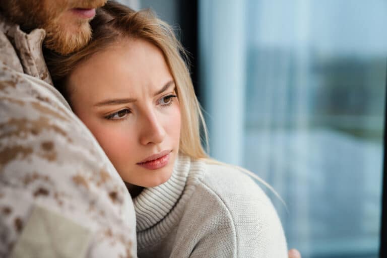 Couple embracing with worried look on woman's face