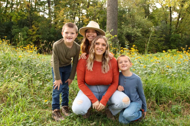 Mother and three children in wildflowers, color photo