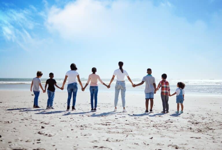 Family with many kids holding hands on beach