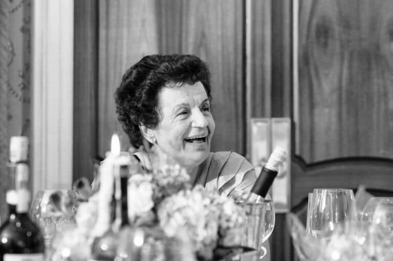 Older woman smiling at wedding table, black-and-white photo