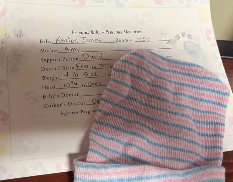Baby hat with hospital certificate announcing stillbirth, color photo