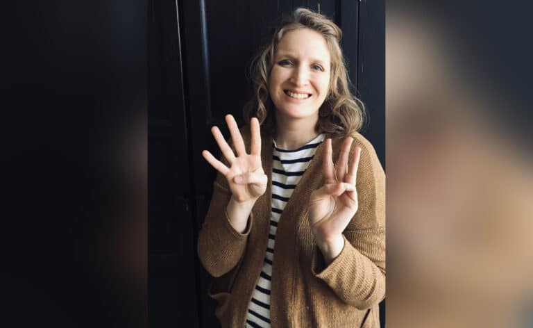 Woman holding up 4 and 3 fingers on her hands