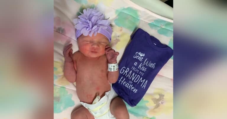 Newborn baby next to a purple onesie about a grandma in heaven