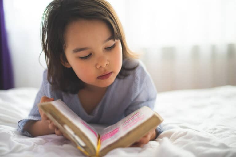 Little girl reading from Bible