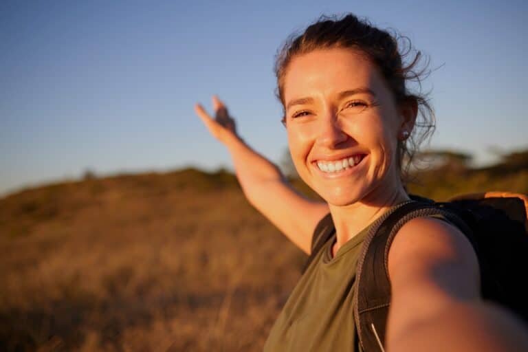 Woman standing alone in field smiling