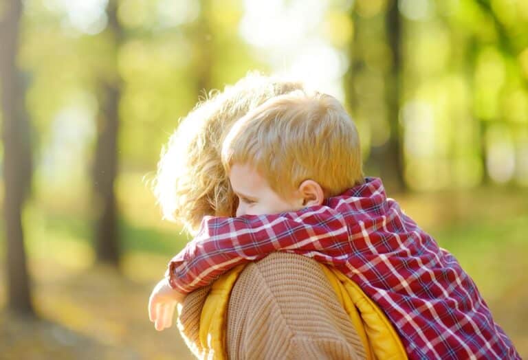 Mother and toddler embrace outside