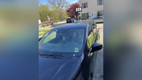 Teen boy in driver's seat of car, color photo