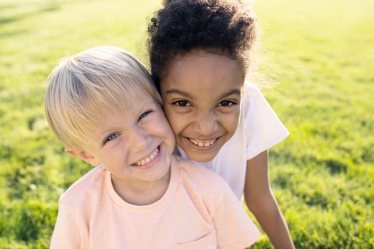 Two kids smiling with cheeks touching