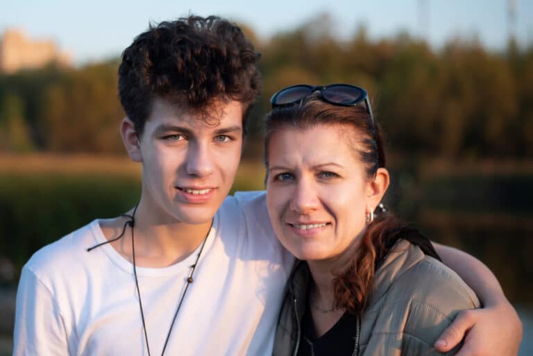 Teen boy hugs mother