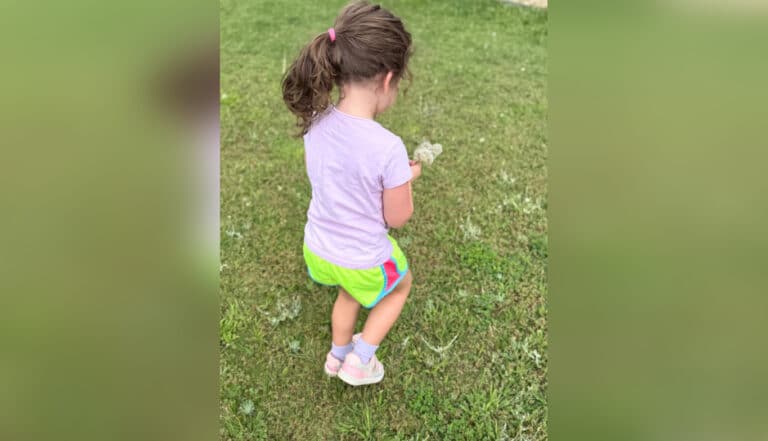 Little girl walking holding leaf