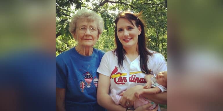 Woman standing with grown daughter who is holding a baby