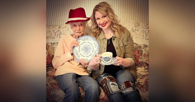 Elderly woman posing with younger woman holding blue patterned dishes