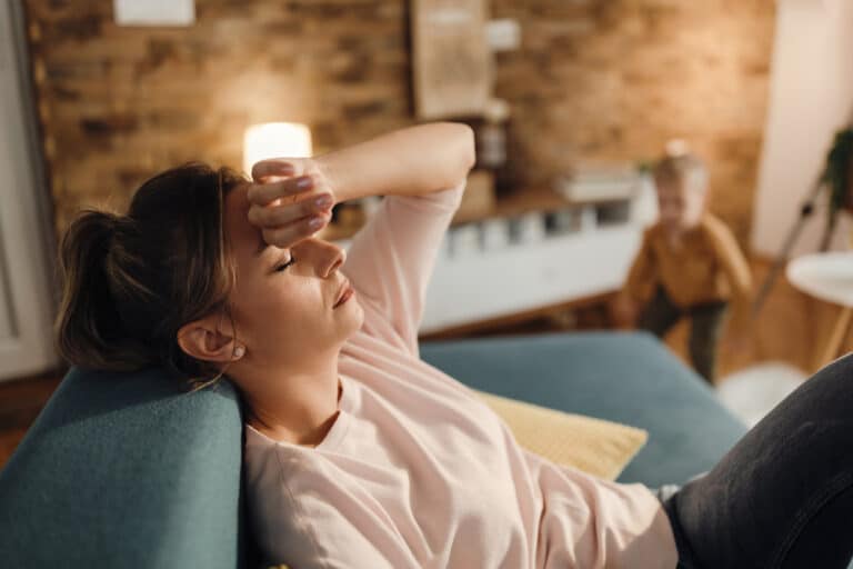 Tired woman with hand on forehead