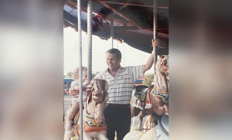 Father and young daughter on carousel, vintage photo