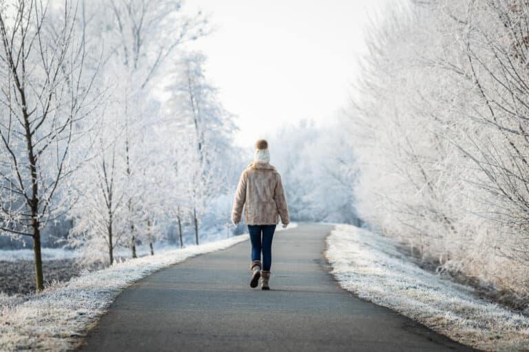 Woman walking along winter path