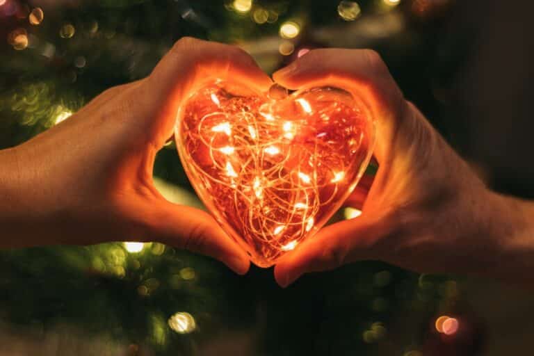 Heart with lights and hands around it