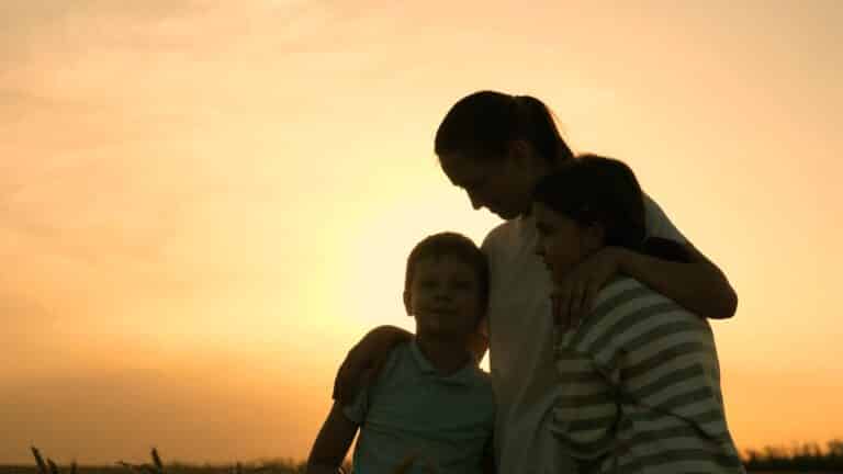 Mother hugging children, silhouette
