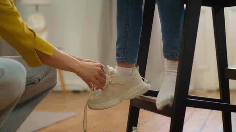Mom tying a child's shoe