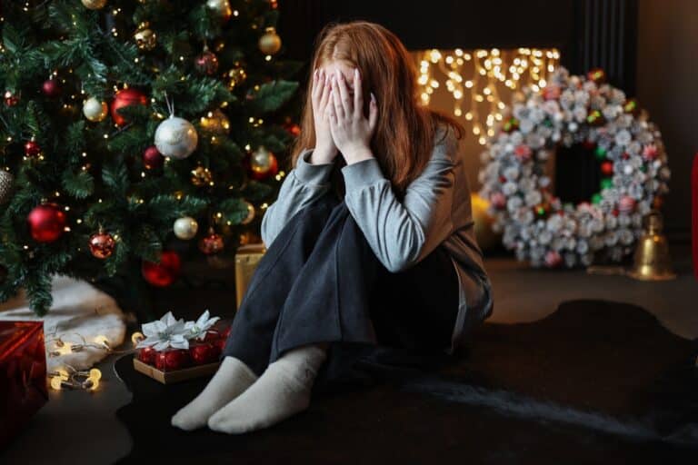 Sad woman sitting by tree