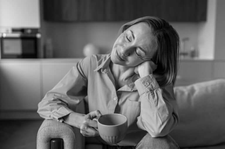 Woman in her 40s sitting with coffee mug
