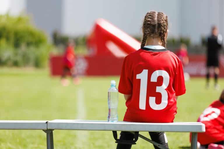 Girl sits on sports bench
