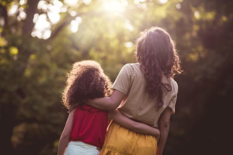 Mother hugging child walking outside