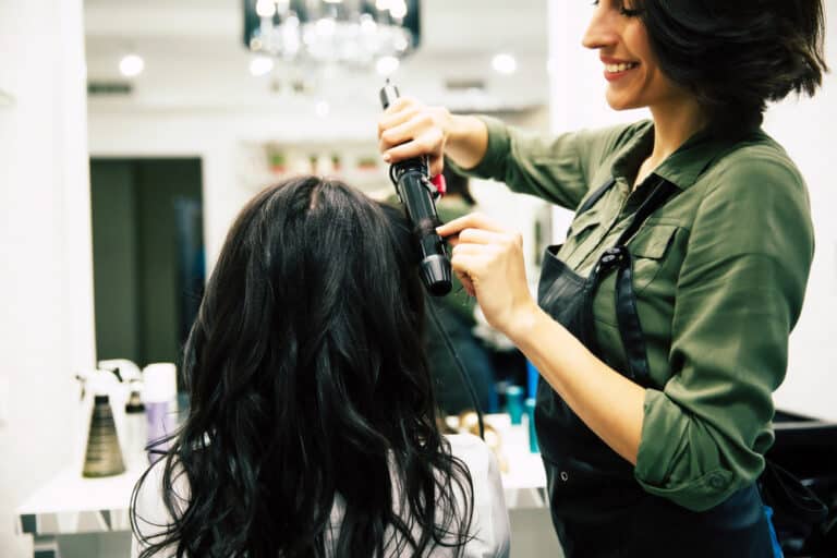 Hair stylist curling client's hair
