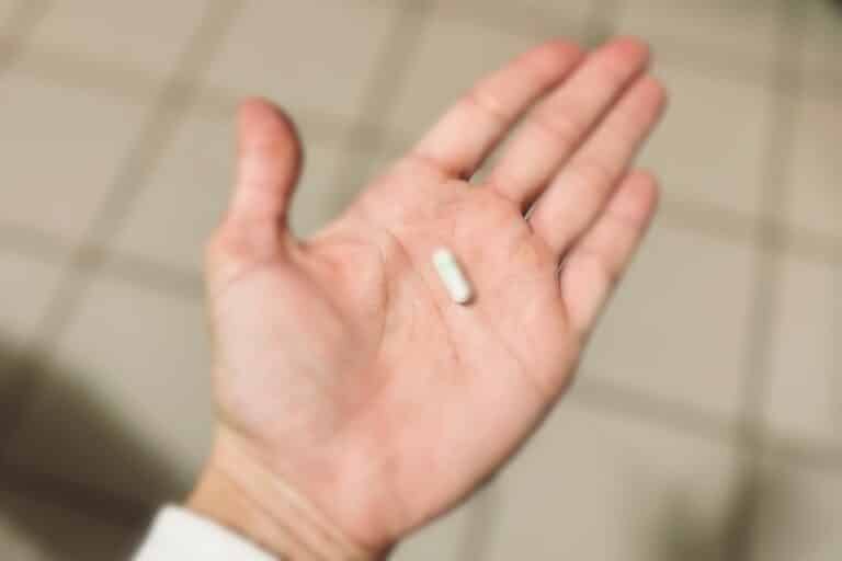 Hand open holding a white pill