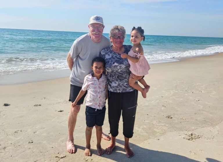 Grandparents pose with grandkids on beach