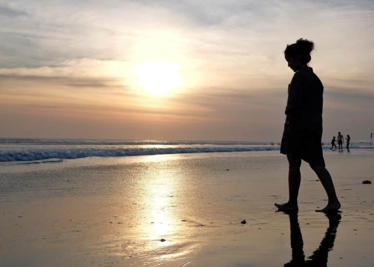 Woman's silhouette standing by water's edge