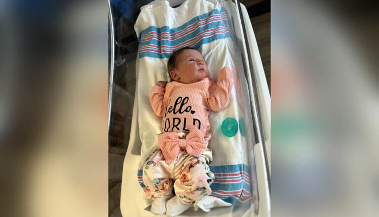 Rainbow baby lying in bassinet