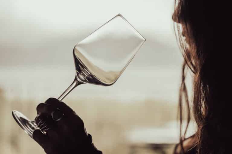 Woman holding empty wine glass to lips