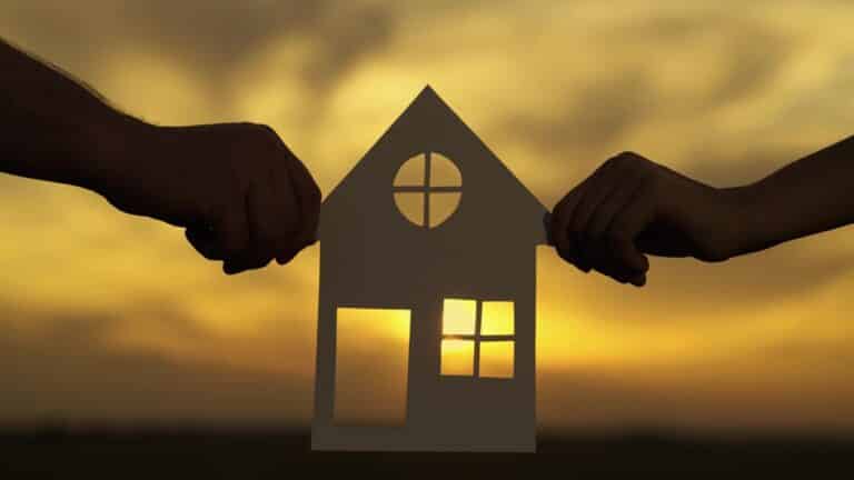 Hands holding cut out of house