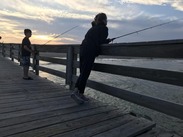 Two people fishing on a dock
