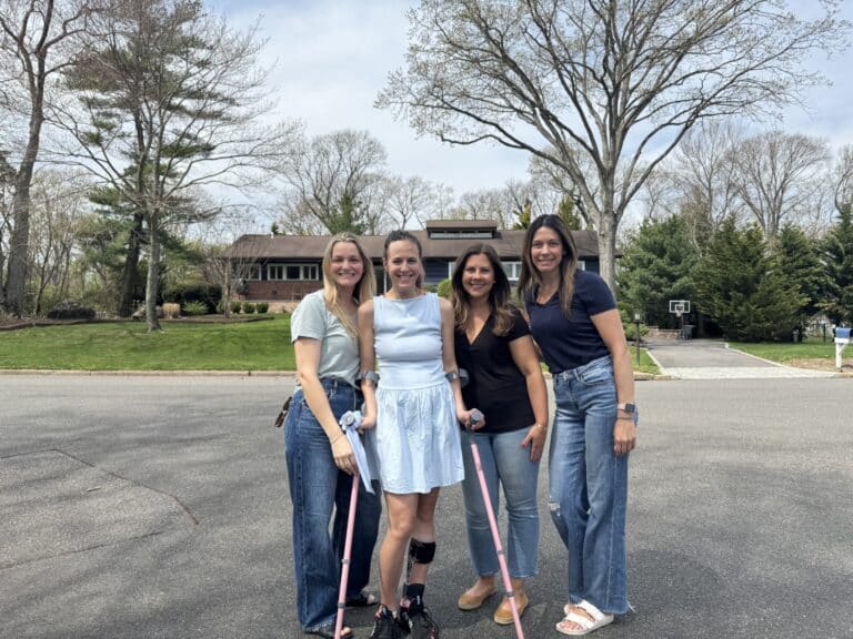 Four women pose in residential street