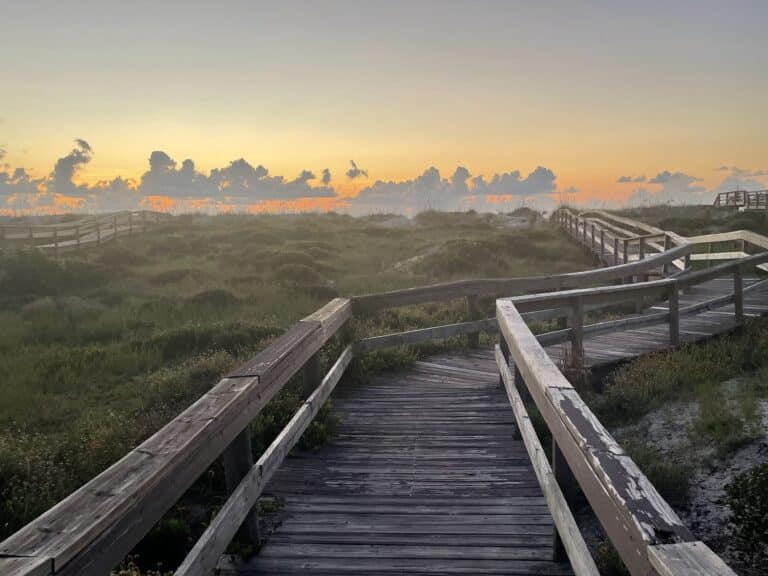 Walkway toward water at sunset