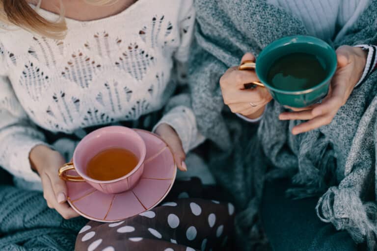 Two women's hands on teacups