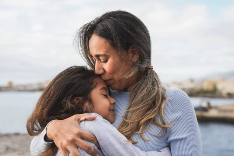 Mom embracing young daughter