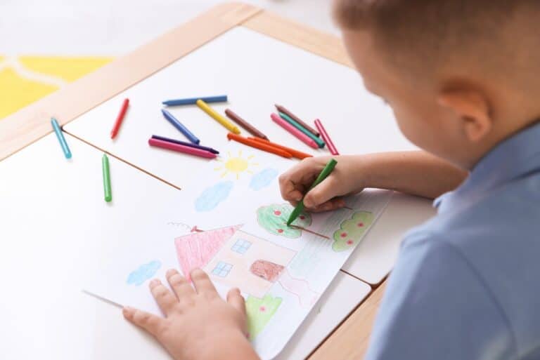 Child coloring with crayons