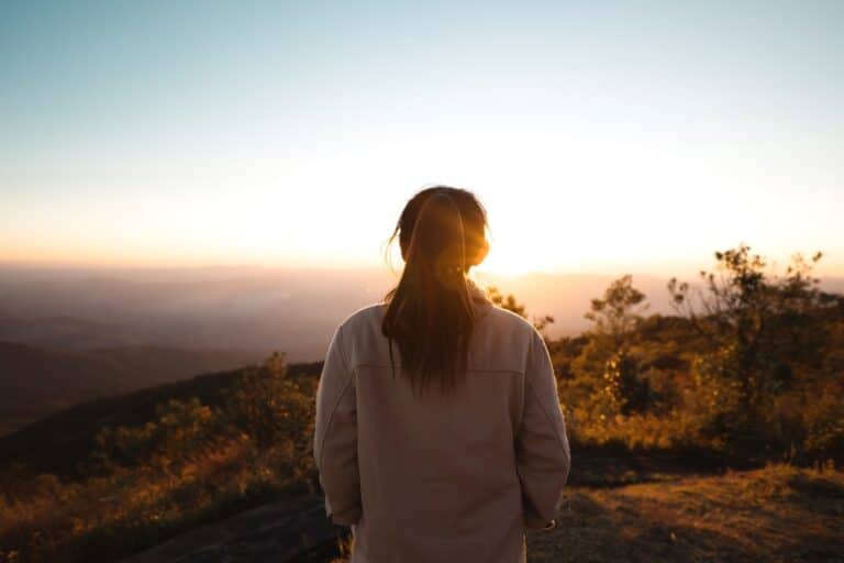 Woman walking towards sunrise